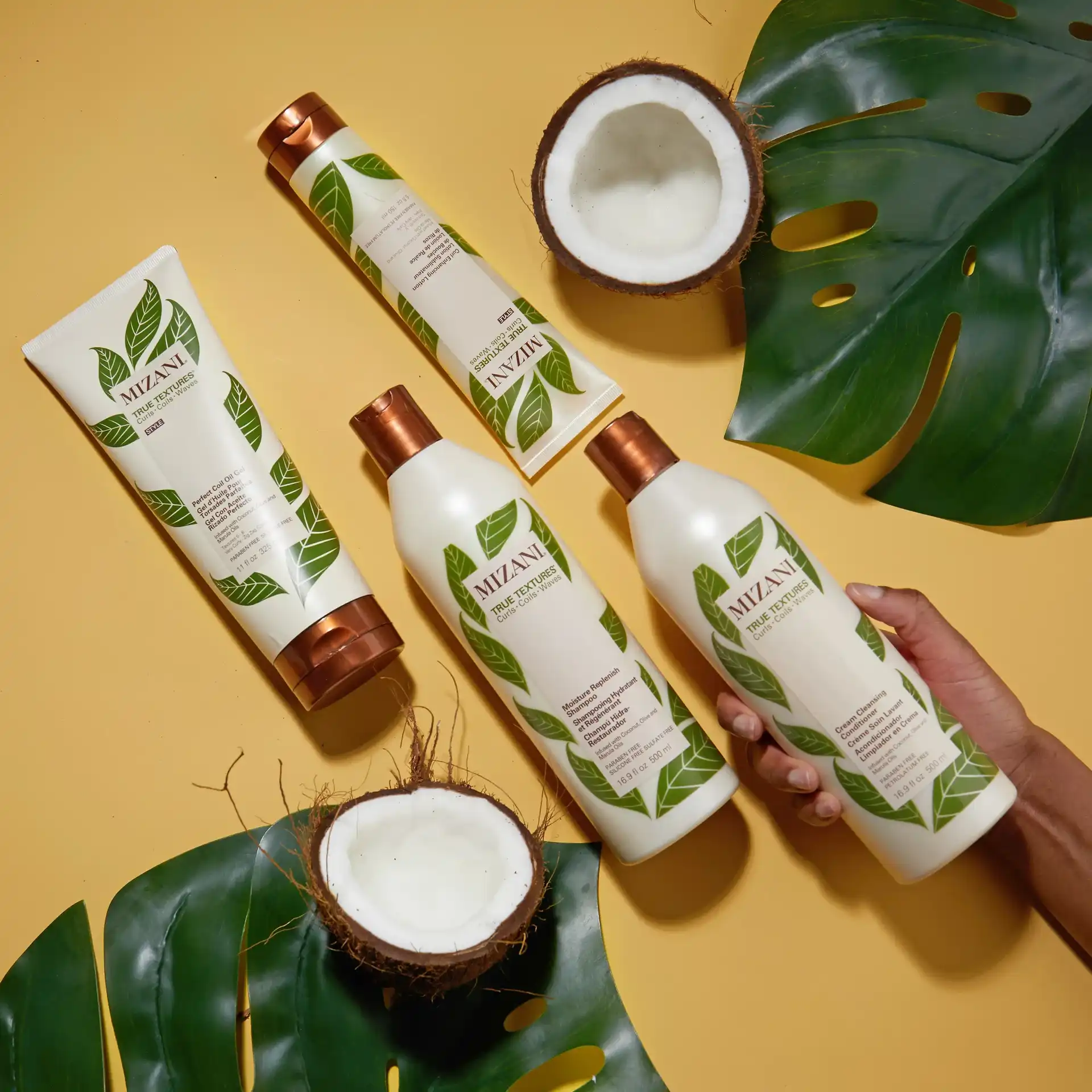 Natural haircare products with coconut and leaves on a yellow background.
